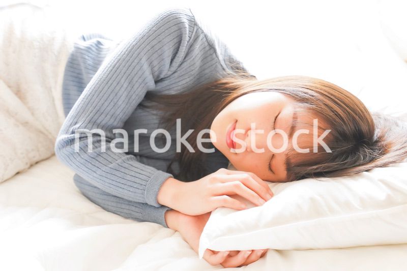 布団に入って睡眠を取る若い女性