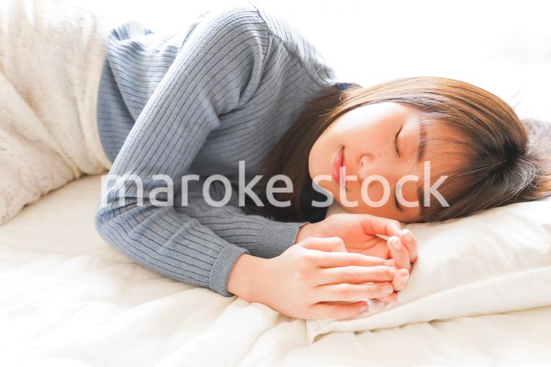 布団に入って睡眠を取る若い女性