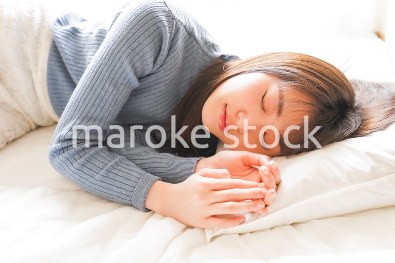 布団に入って睡眠を取る若い女性