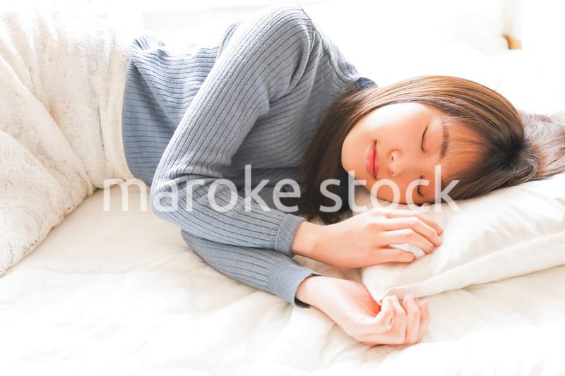 布団に入って睡眠を取る若い女性