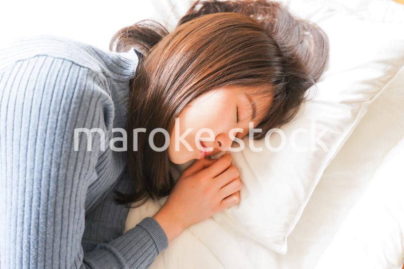 布団に入って睡眠を取る若い女性
