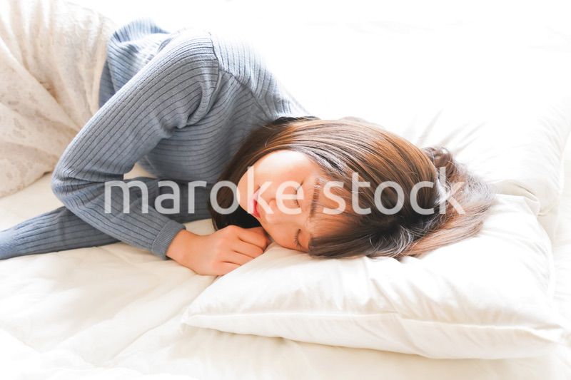 布団に入って睡眠を取る若い女性