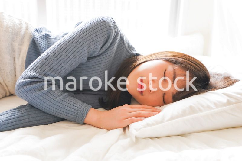 布団に入って睡眠を取る若い女性