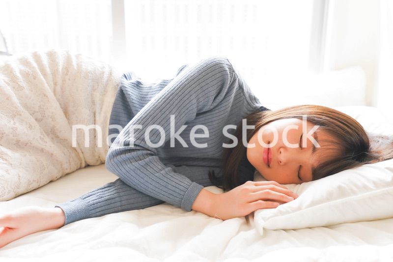 布団に入って睡眠を取る若い女性