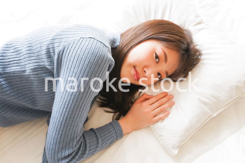 布団に入って睡眠を取る若い女性