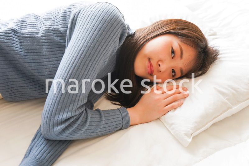 布団に入って睡眠を取る若い女性