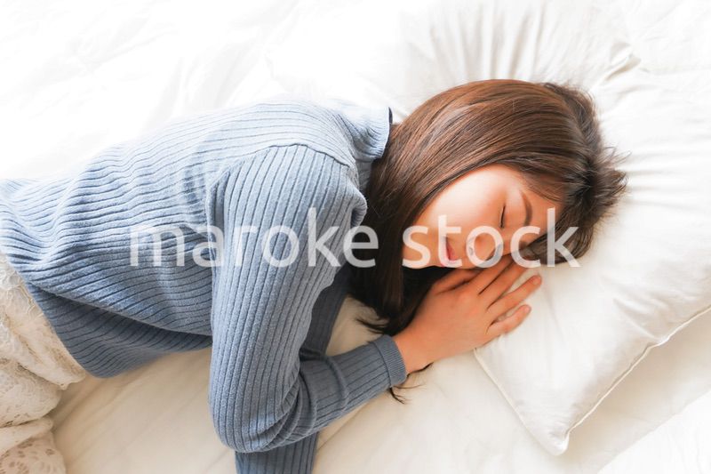 布団に入って睡眠を取る若い女性
