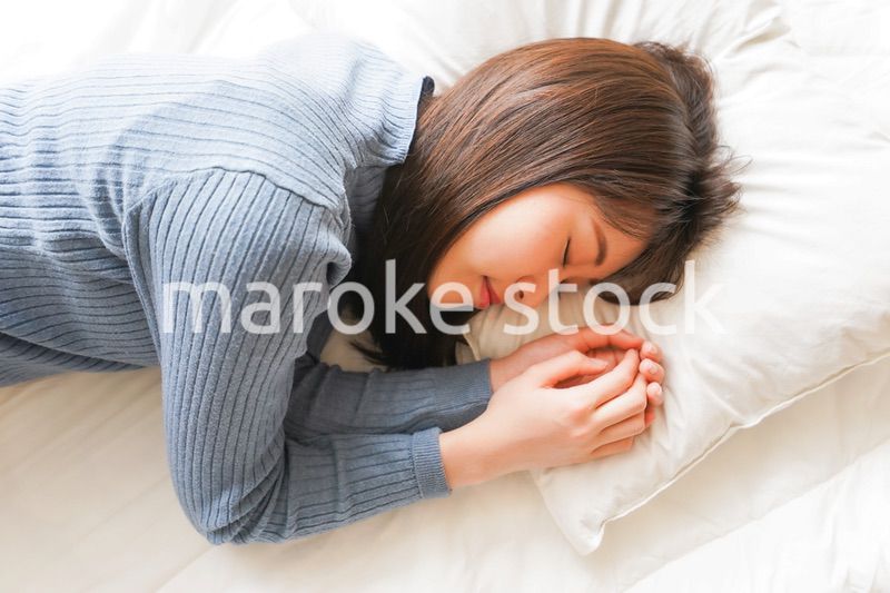 布団に入って睡眠を取る若い女性