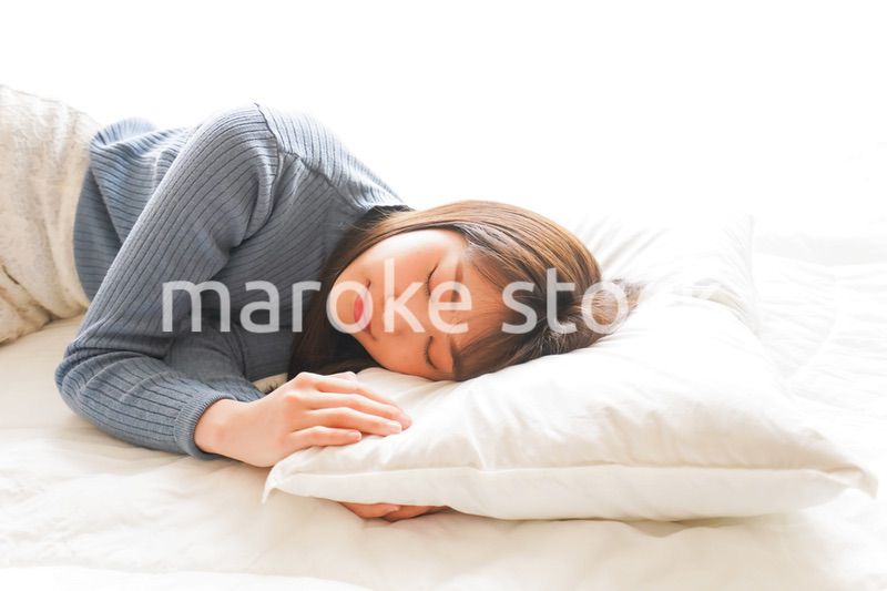 布団に入って睡眠を取る若い女性