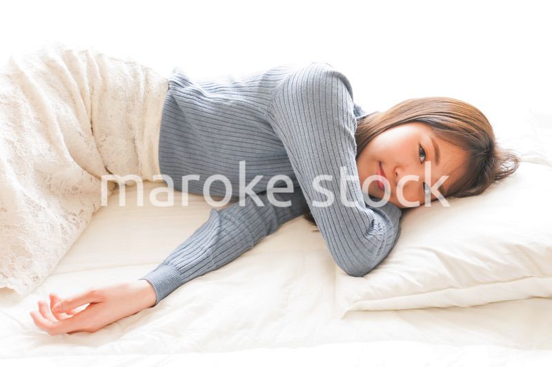 布団に入って睡眠を取る若い女性