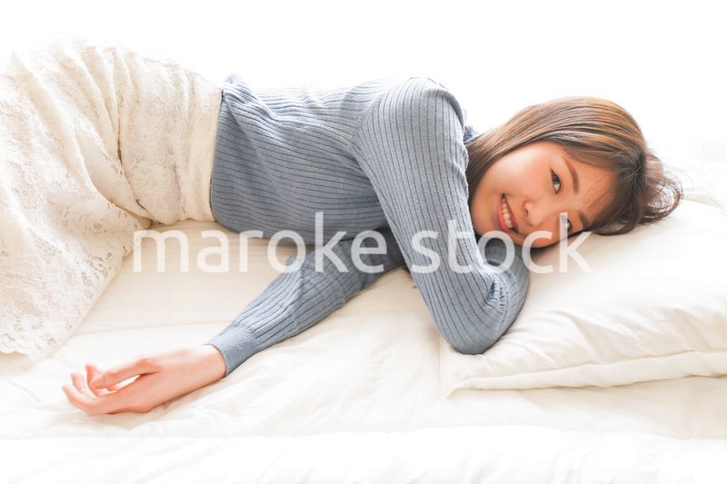 布団に入って睡眠を取る若い女性