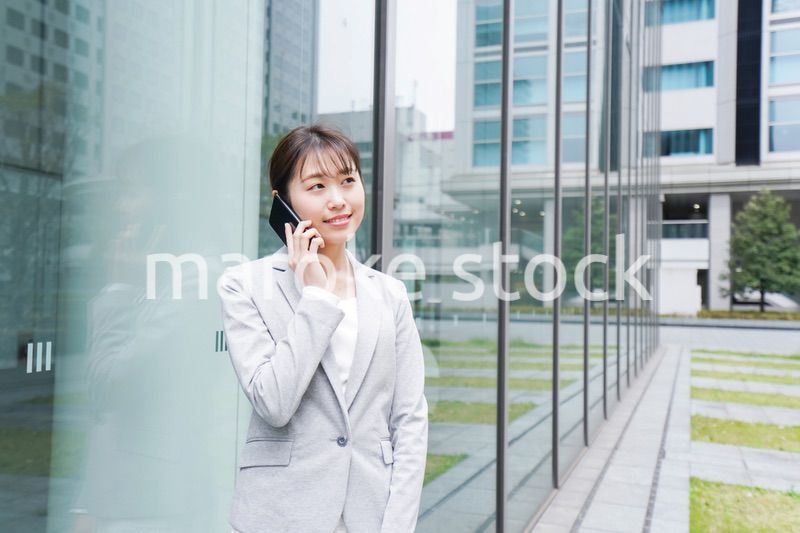 オフィス街で電話をする若いビジネスウーマン