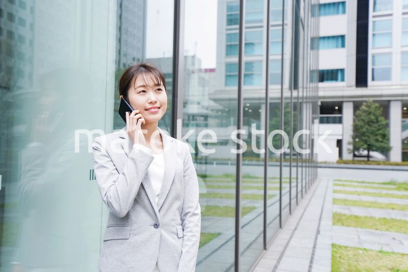 オフィス街で電話をする若いビジネスウーマン