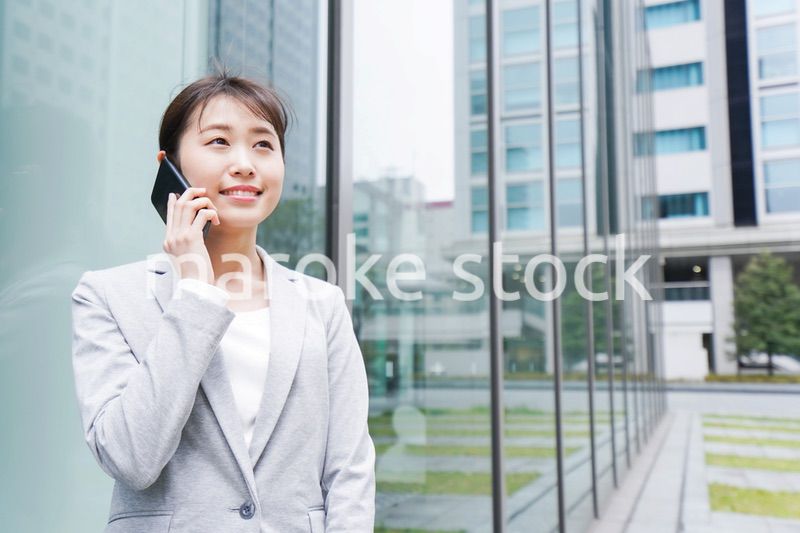 オフィス街で電話をする若いビジネスウーマン