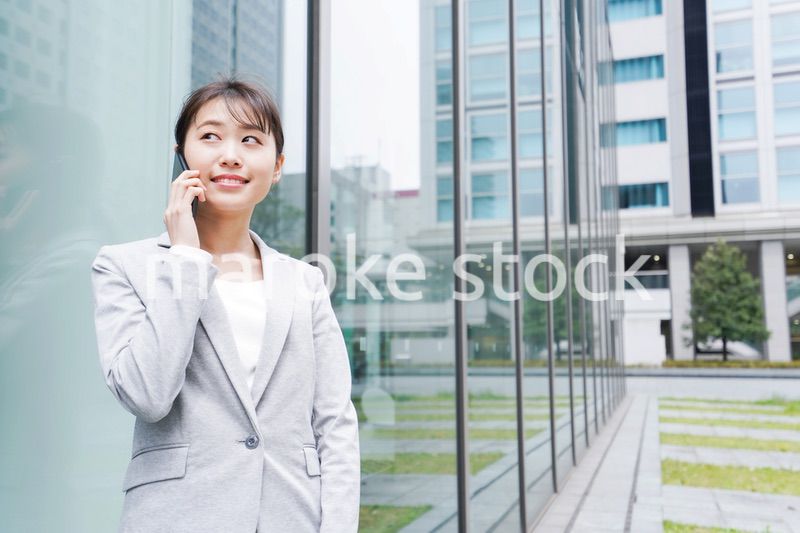オフィス街で電話をする若いビジネスウーマン