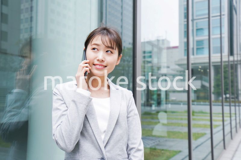 オフィス街で電話をする若いビジネスウーマン