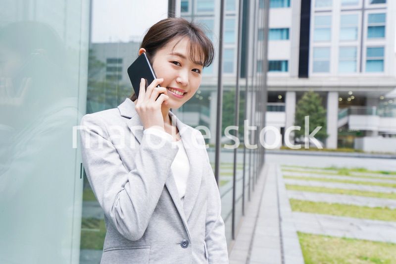 オフィス街で電話をする若いビジネスウーマン