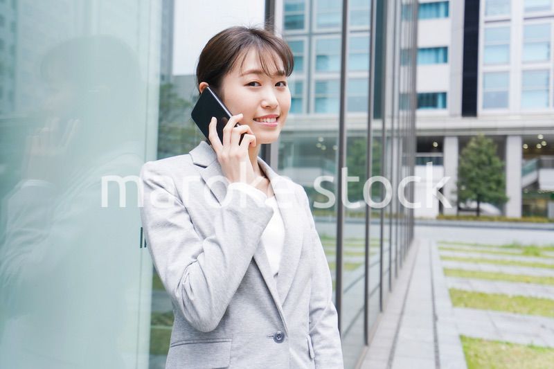 オフィス街で電話をする若いビジネスウーマン