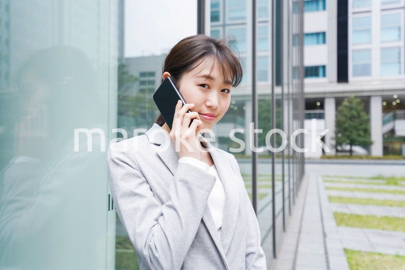 オフィス街で電話をする若いビジネスウーマン