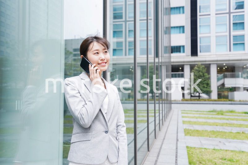 オフィス街で電話をする若いビジネスウーマン