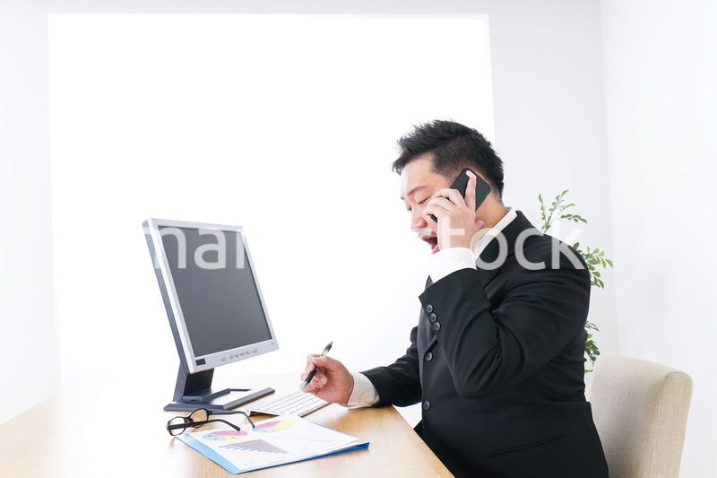 オフィスで電話をするビジネスマン