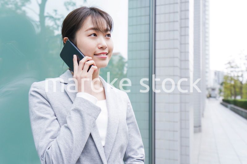 オフィス街で電話をする若いビジネスウーマン