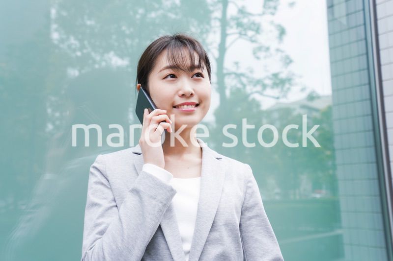 オフィス街で電話をする若いビジネスウーマン