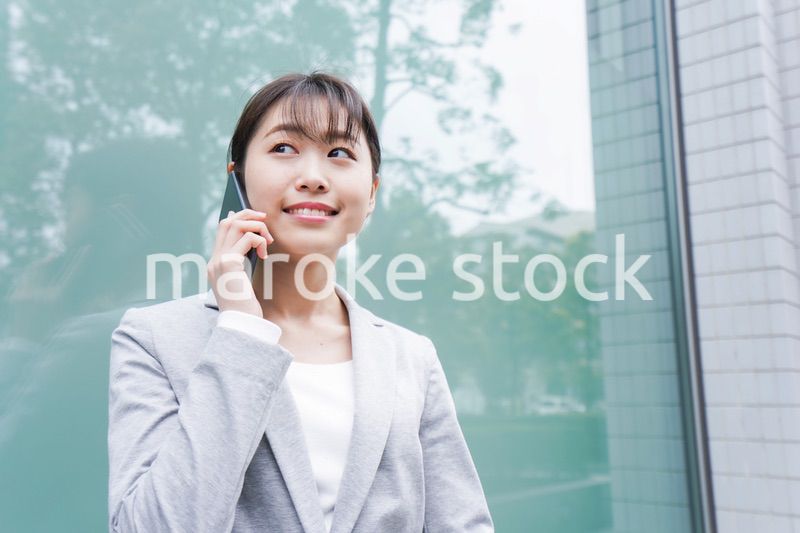 オフィス街で電話をする若いビジネスウーマン