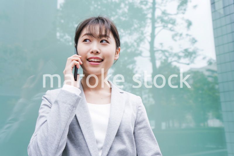 オフィス街で電話をする若いビジネスウーマン