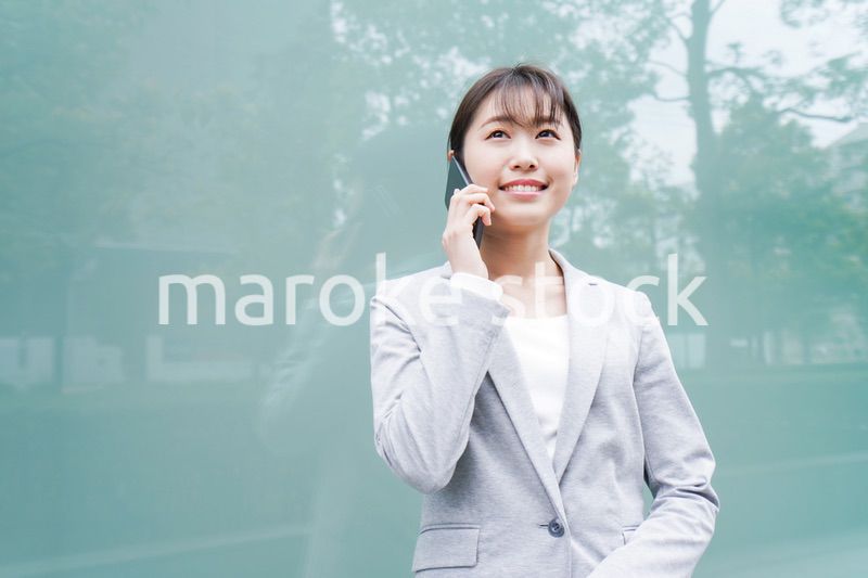 オフィス街で電話をする若いビジネスウーマン