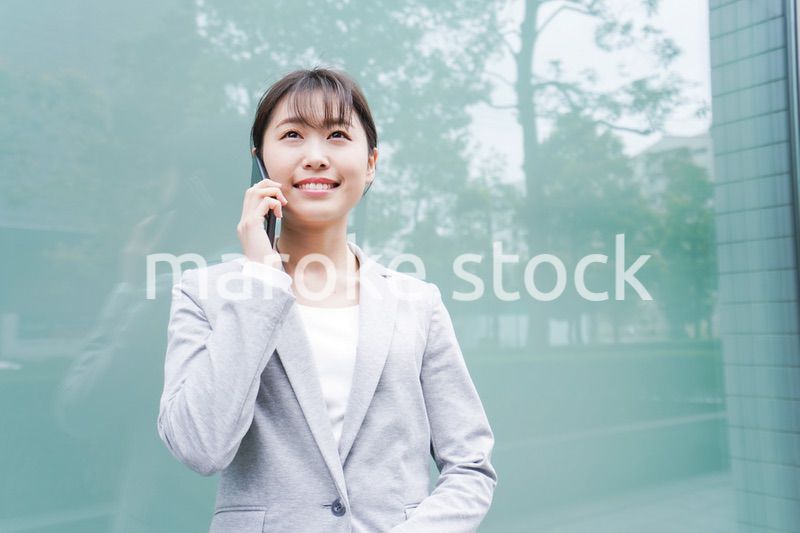 オフィス街で電話をする若いビジネスウーマン
