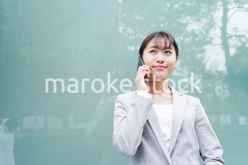 オフィス街で電話をする若いビジネスウーマン