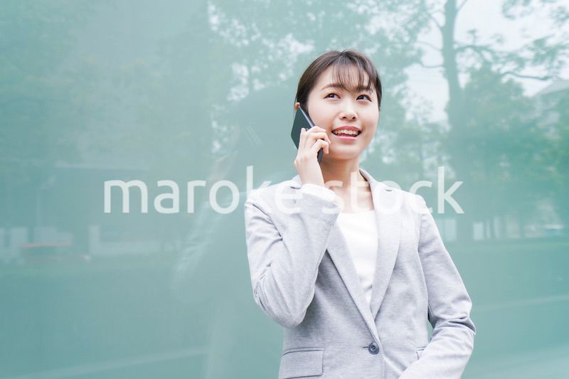 オフィス街で電話をする若いビジネスウーマン