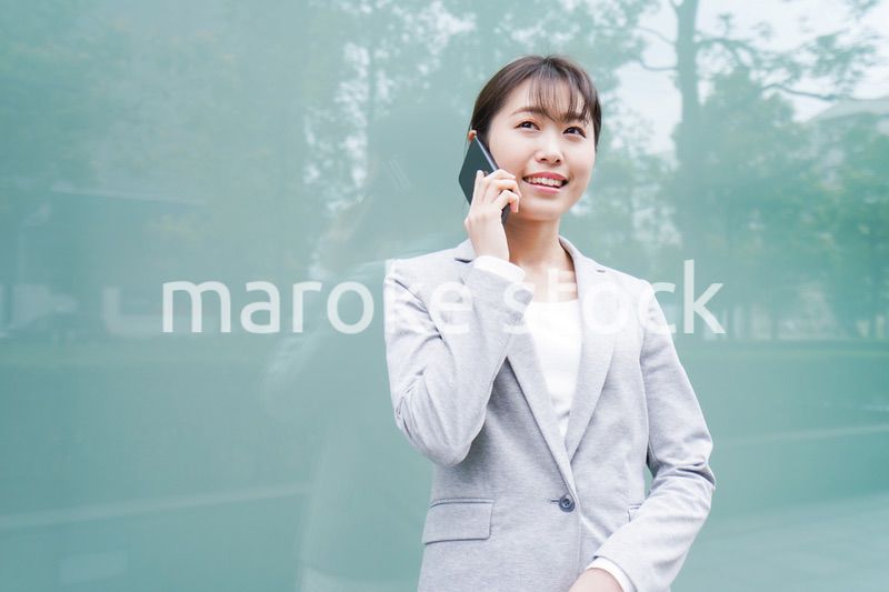オフィス街で電話をする若いビジネスウーマン