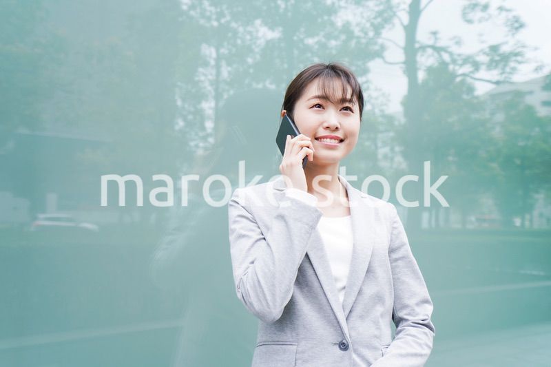 オフィス街で電話をする若いビジネスウーマン
