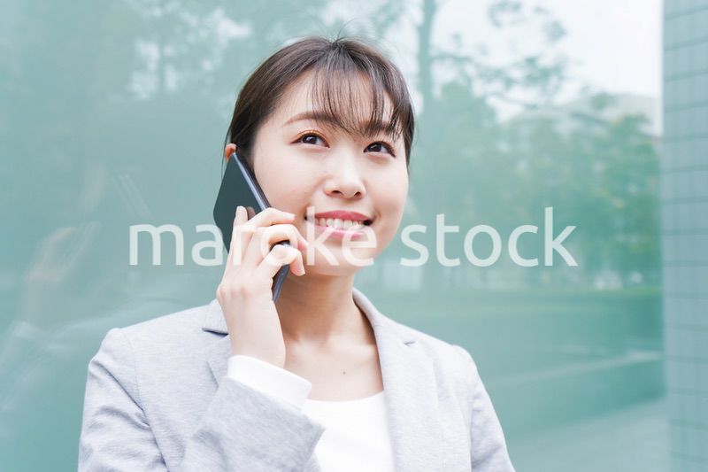 オフィス街で電話をする若いビジネスウーマン