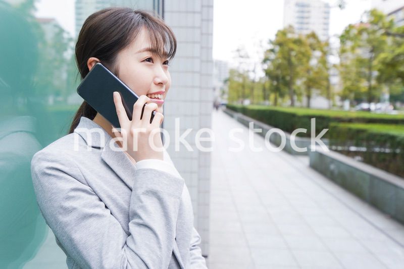 オフィス街で電話をする若いビジネスウーマン