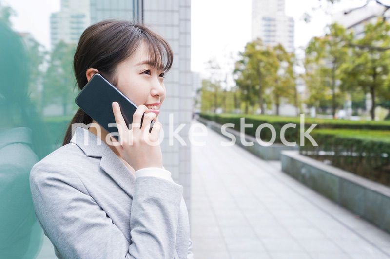 オフィス街で電話をする若いビジネスウーマン