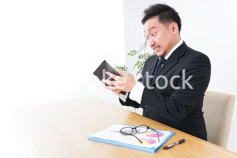 財布を見て驚くビジネスマン