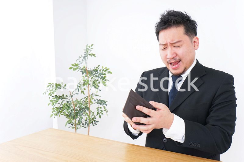 財布を見て驚くビジネスマン