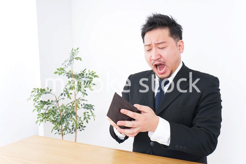 財布を見て驚くビジネスマン