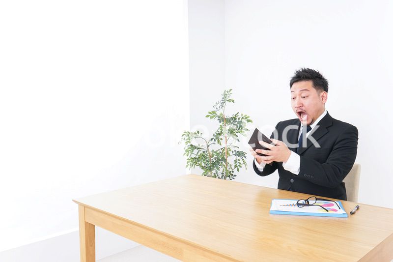 財布を見て驚くビジネスマン