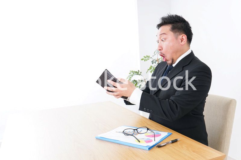 財布を見て驚くビジネスマン