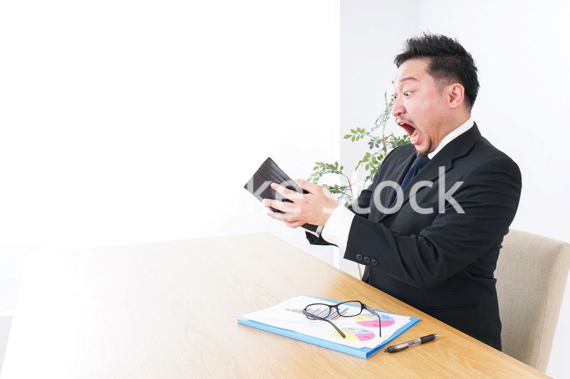 財布を見て驚くビジネスマン