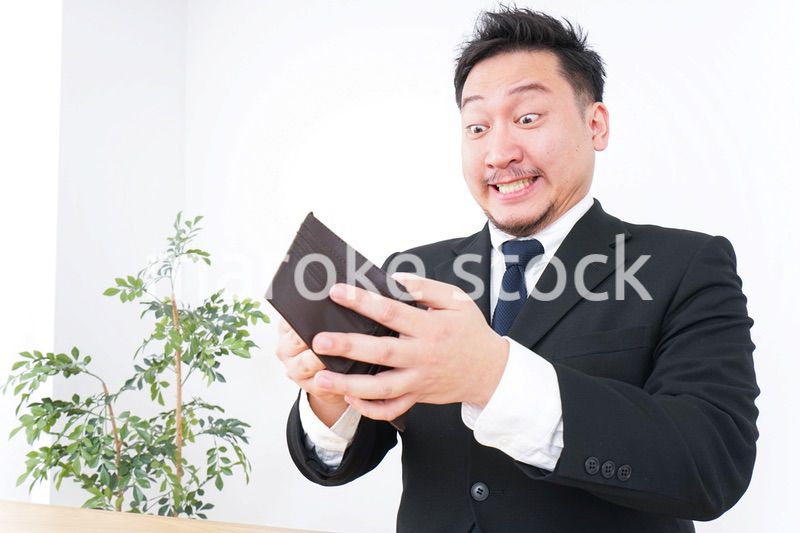 財布を見て驚くビジネスマン