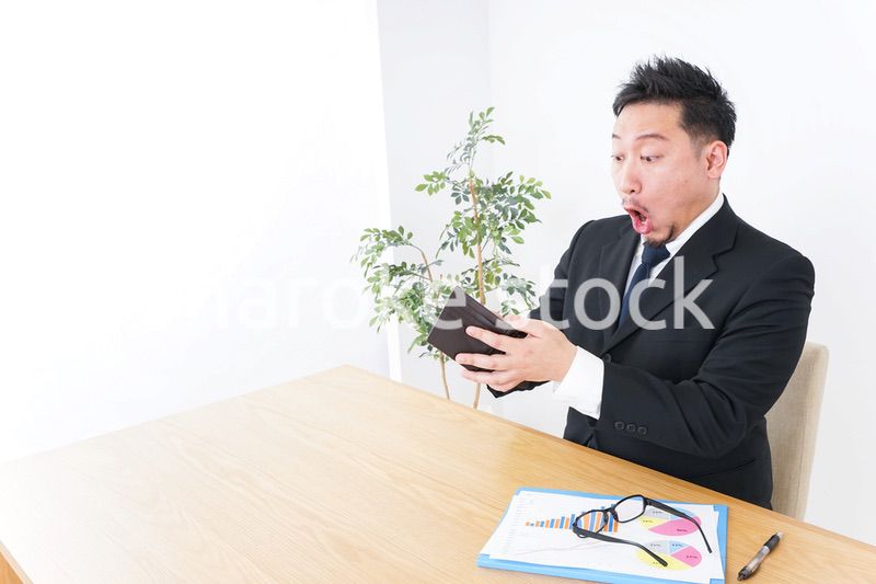 財布を見て驚くビジネスマン