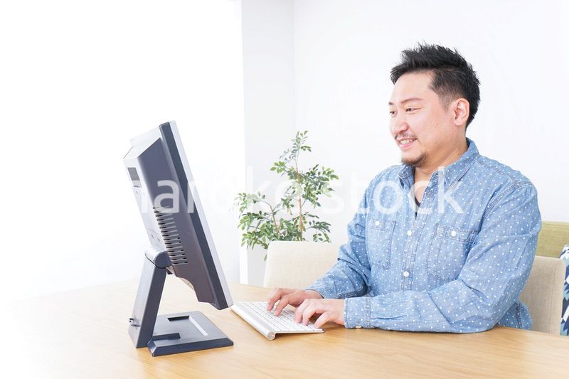 家でパソコンを使う男性