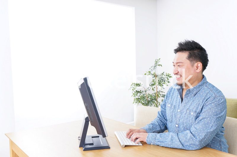 家でパソコンを使う男性