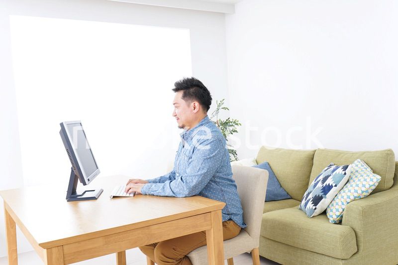 家でパソコンを使う男性