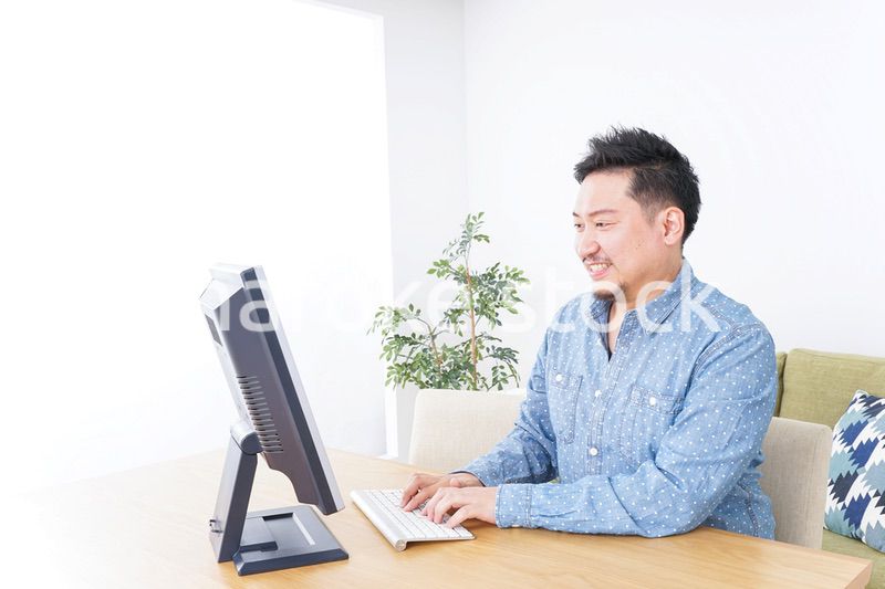 家でパソコンを使う男性